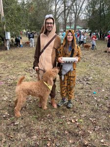 Adult and child dressed as dogs with a dog celebrating Easter Egg Hunt for Dogs