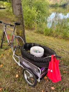 Moving the tire recovered and bucket of debris by bike for proper disposal